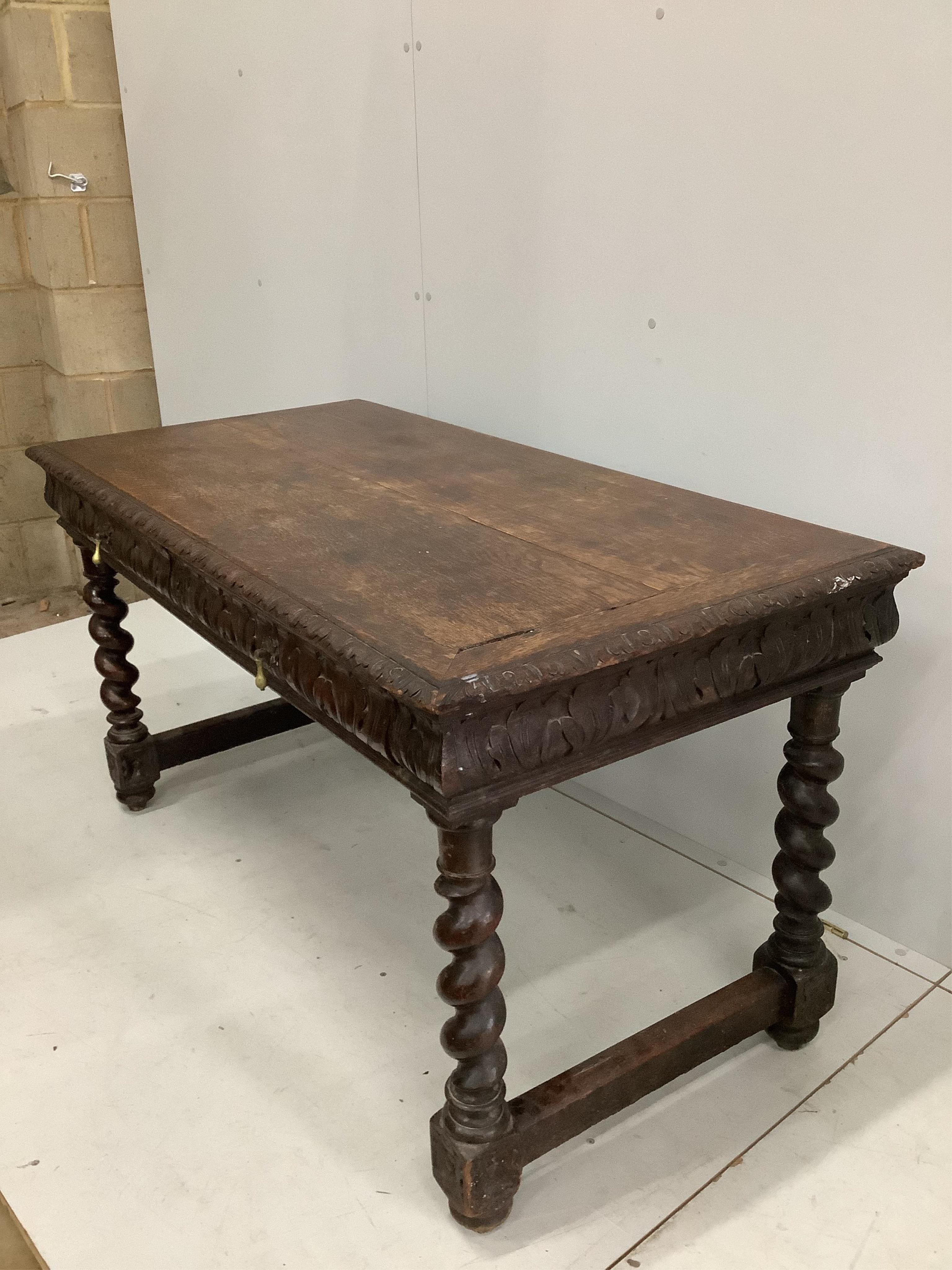 An early 20th century carved oak two drawer writing table, width 133cm, depth 67cm, height 72cm. Condition - fair